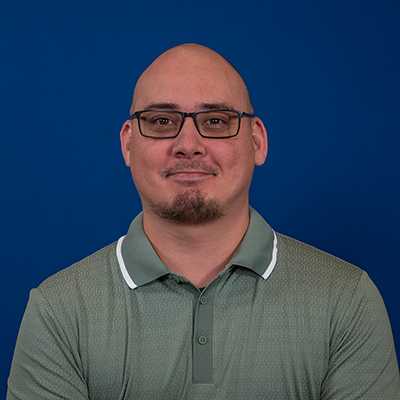 A light skinned Asian American man in his 30s smiling at the camera.